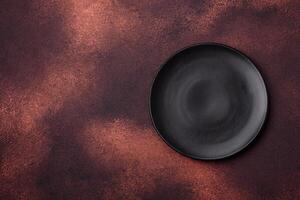 Empty ceramic round plate on dark textured concrete background photo