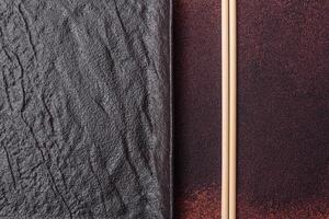 Empty black square ceramic plate on dark concrete background photo