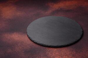 Empty ceramic round plate on dark textured concrete background photo