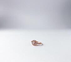 Beautiful rose gold with diamond shiny round crystal design. One single fashion object photography isolated on white studio background. Expensive luxury styled engagement ring. photo