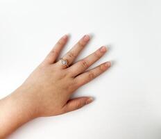 Human left hand with rose gold and diamond round designed ring on the ring finger. Object photography isolated on white studio background. photo