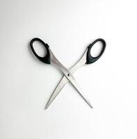 Stainless steel opened scissors with black colored handle. Cutting object photography isolated on plain studio background. photo