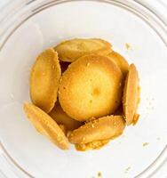 Close up round plain sweet bakery food biscuit treats inside clear plastic glass jar container. Object photography isolated on white studio background. photo