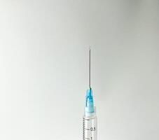 Syringe for injection. Sharp and pointy close up needle tip photography isolated on horizontal copy spaced plain white studio background with no text and nobody. photo