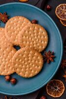 Round dotted snack snack cookies with cream on a dark concrete background photo