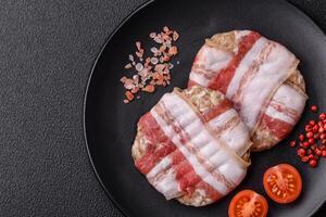 Round minced chicken or pork cutlet wrapped in bacon with salt, spices and herbs photo