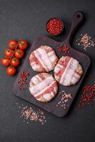 Round minced chicken or pork cutlet wrapped in bacon with salt, spices and herbs photo