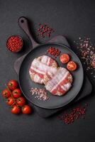 Round minced chicken or pork cutlet wrapped in bacon with salt, spices and herbs photo