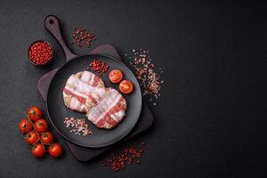 Round minced chicken or pork cutlet wrapped in bacon with salt, spices and herbs photo