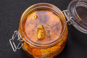 Delicious soft white feta cheese with salt, spices and herbs on a dark concrete background photo