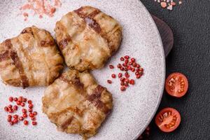 Round minced chicken or pork cutlet wrapped in bacon with salt, spices and herbs photo
