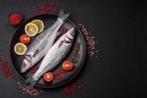 Fresh raw ocean sea bass fish with salt, spices and herbs photo