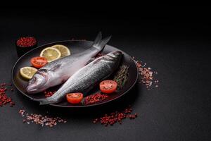 Fresh raw ocean sea bass fish with salt, spices and herbs photo