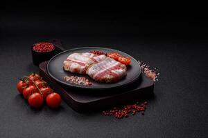 Round minced chicken or pork cutlet wrapped in bacon with salt, spices and herbs photo