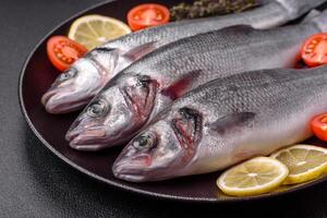 Fresco crudo Oceano mar bajo pescado con sal, especias y hierbas foto