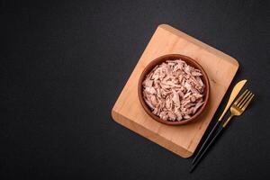 Delicious canned dietary tuna meat with salt, spices and oil photo