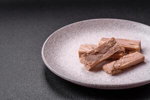 Delicious canned dietary tuna meat with salt, spices and oil photo