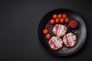 Round minced chicken or pork cutlet wrapped in bacon with salt, spices and herbs photo