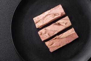 Delicious canned dietary tuna meat with salt, spices and oil photo