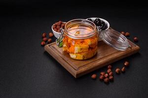 Delicious soft white feta cheese with salt, spices and herbs on a dark concrete background photo