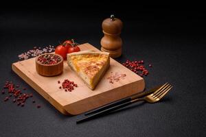 Delicious crispy quiche cut into slices with cheese, broccoli, tomatoes photo
