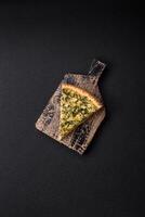 Delicious crispy quiche cut into slices with cheese, broccoli, tomatoes photo