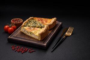 Delicious crispy quiche cut into slices with cheese, broccoli, tomatoes photo