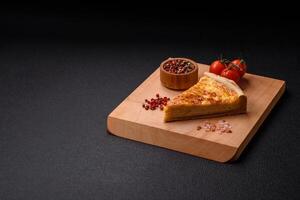 Delicious crispy quiche cut into slices with cheese, broccoli, tomatoes photo