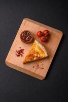 Delicious crispy quiche cut into slices with cheese, broccoli, tomatoes photo