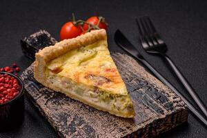 Delicious crispy quiche cut into slices with cheese, broccoli, tomatoes photo