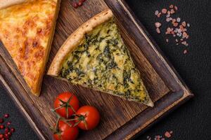 Delicious crispy quiche cut into slices with cheese, broccoli, tomatoes photo