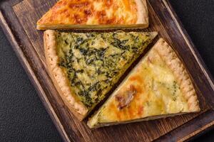 Delicious crispy quiche cut into slices with cheese, broccoli, tomatoes photo