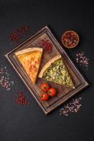 Delicious crispy quiche cut into slices with cheese, broccoli, tomatoes photo