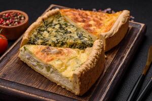 Delicious crispy quiche cut into slices with cheese, broccoli, tomatoes photo