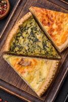 Delicious crispy quiche cut into slices with cheese, broccoli, tomatoes photo