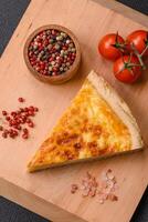 Delicious crispy quiche cut into slices with cheese, broccoli, tomatoes photo