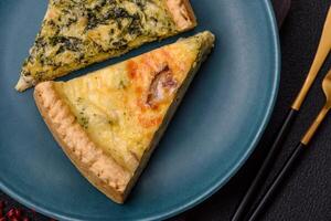 Delicious crispy quiche cut into slices with cheese, broccoli, tomatoes photo