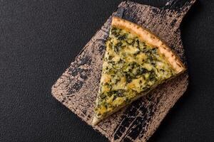 Delicious crispy quiche cut into slices with cheese, broccoli, tomatoes photo