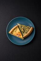 Delicious crispy quiche cut into slices with cheese, broccoli, tomatoes photo