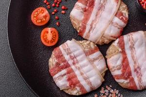 Round minced chicken or pork cutlet wrapped in bacon with salt, spices and herbs photo