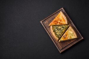 Delicious crispy quiche cut into slices with cheese, broccoli, tomatoes photo