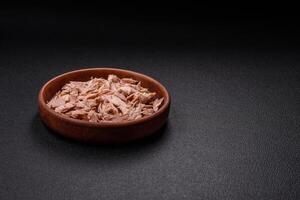 Delicious canned dietary tuna meat with salt, spices and oil photo