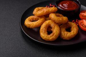 Delicious nutritious squid or onion rings deep fried with salt and spices photo