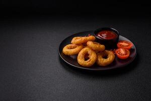 Delicious nutritious squid or onion rings deep fried with salt and spices photo