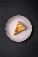 Delicious crispy quiche cut into slices with cheese, broccoli, tomatoes photo