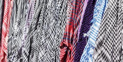 Traditional Keffiyeh or kefia hanging on hangers on bazaar in Egypt photo