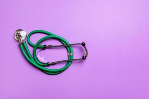 Top view of green medical stethoscope on colorful background with copy space. Medicine equipment concept photo