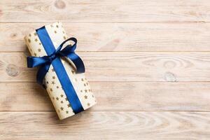 Beautiful gift box with a colored bow on the yellow wooden table. Top view banner with copy space for you design photo