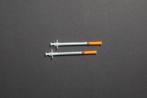 Top view of insulin syringes ready for injection on colorful background. Diabetic concept with copy space photo