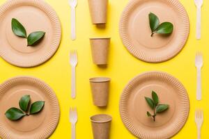 set of empty reusable disposable eco-friendly plates, cups, utensils on light white colored table background. top view. Biodegradable craft dishes. Recycling concept. Close-up photo